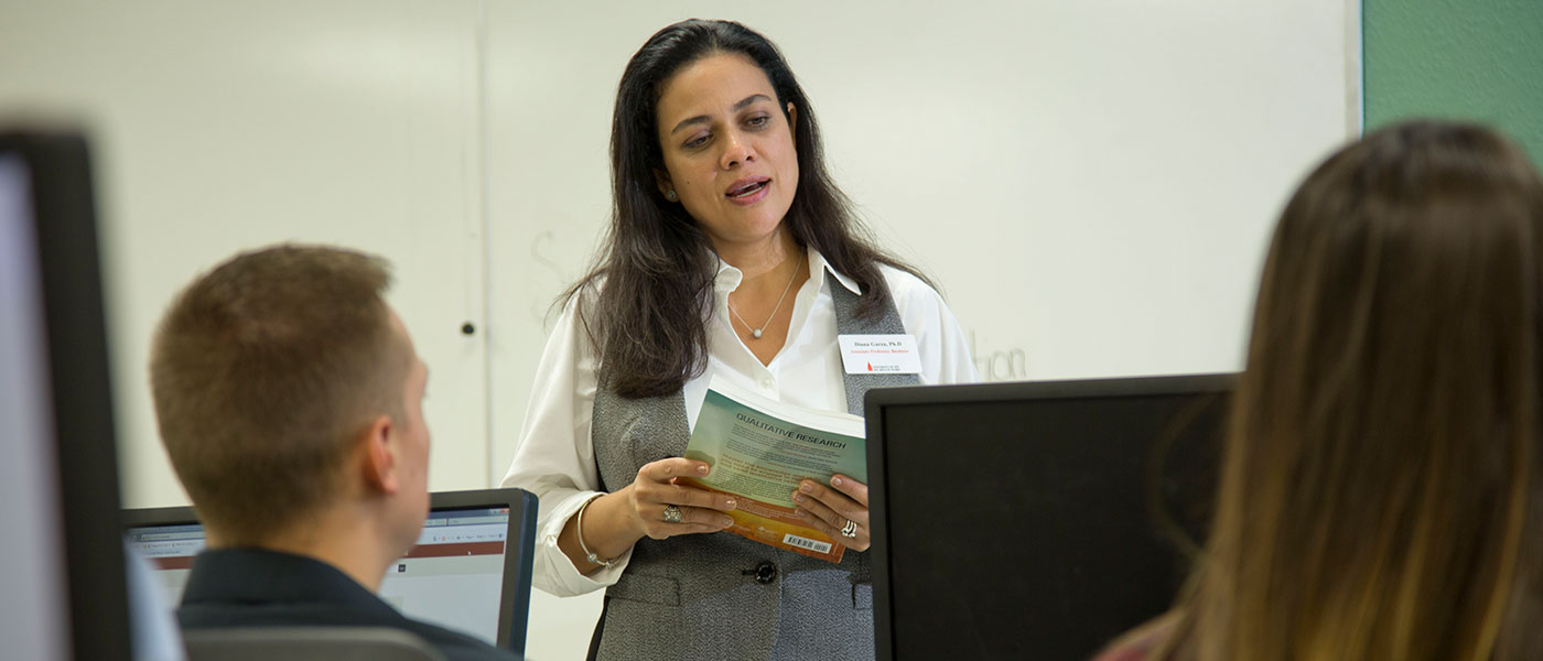 Female faculty member teaching a classroom on computers.