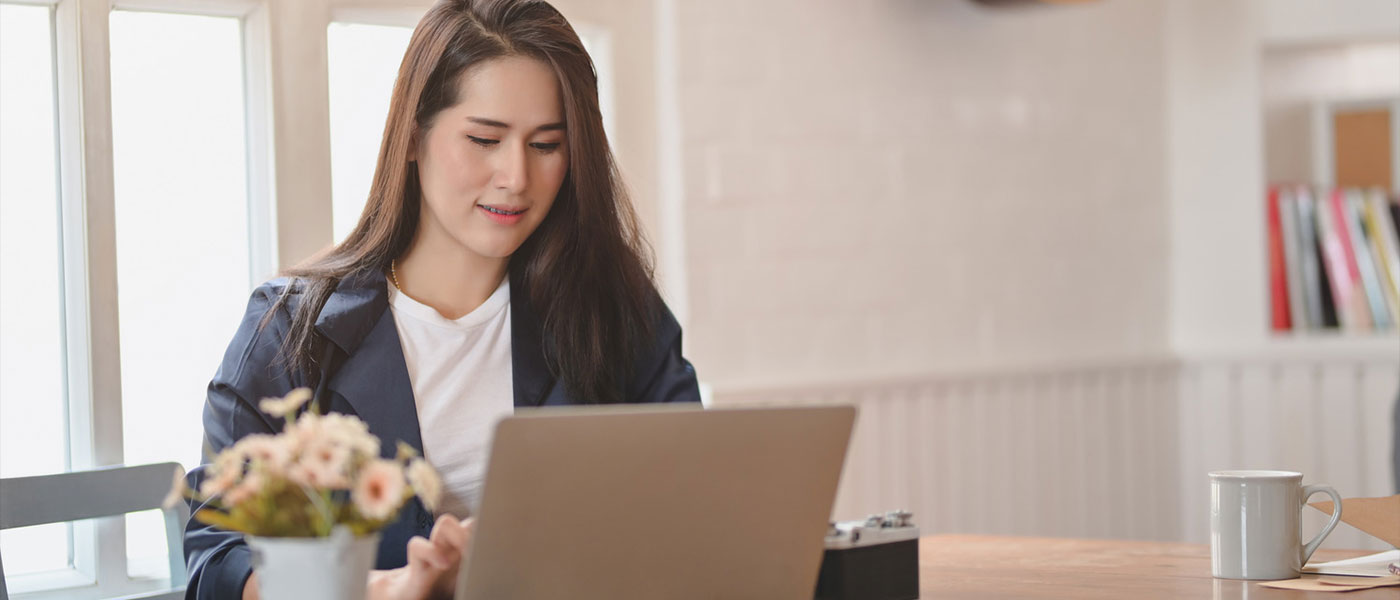 Middle-aged women in her kitchen on her laptop