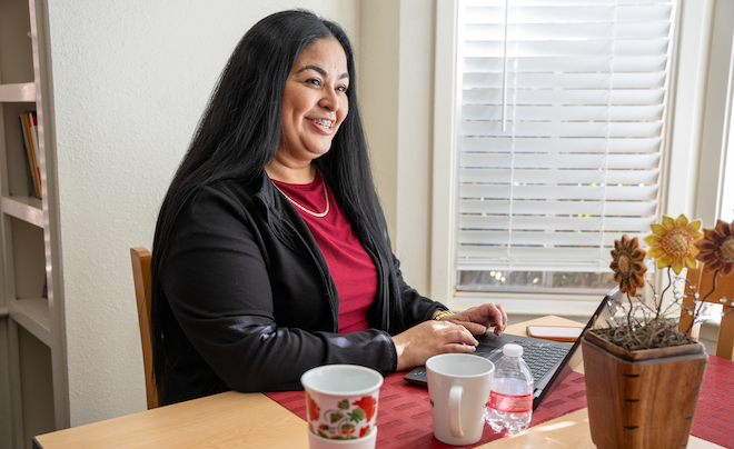 Woman smiling using laptop