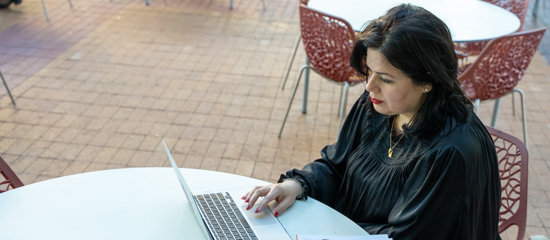 Student sitting outside on their laptop.
