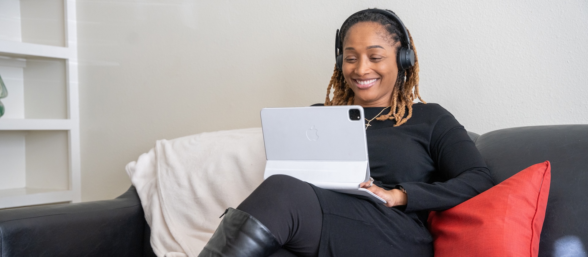 Stdent sittin on a couch with their tablet.