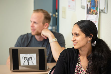 man and woman smiling paying attention in class