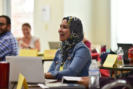 woman in hijab smiling looking away from camera