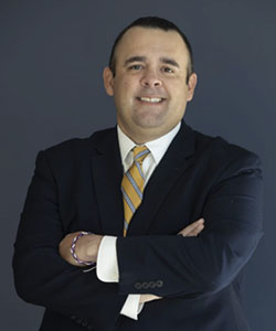 Portrait of DBA student Alexander Rodriguez in a suit