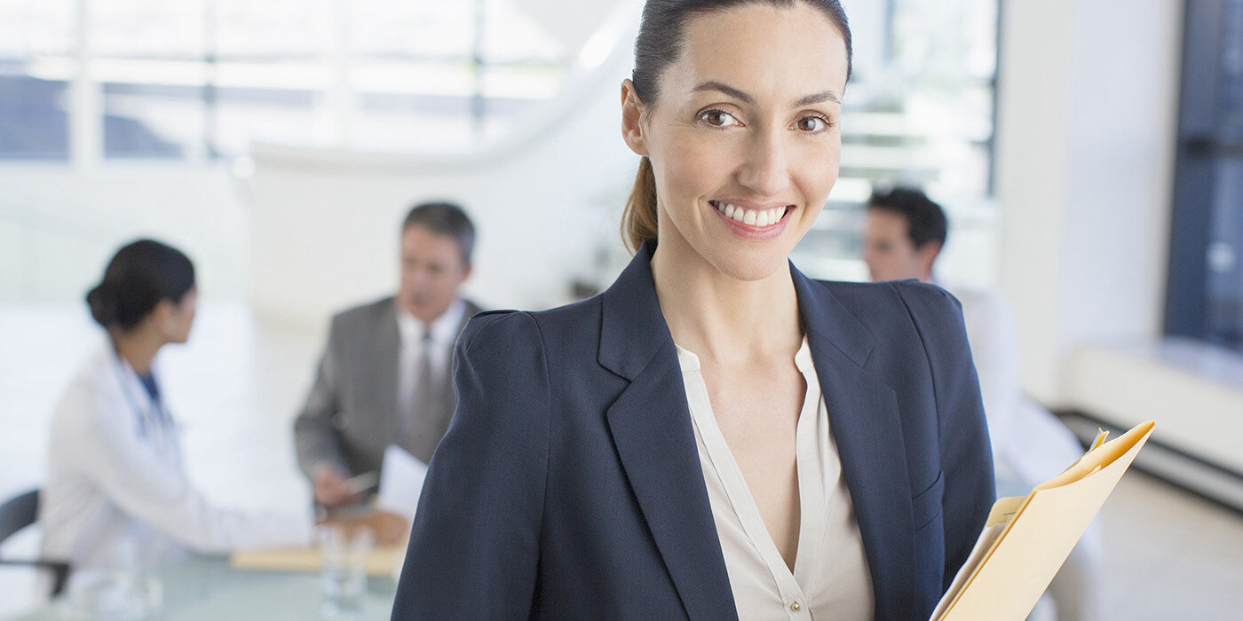 Women smiling holding folders