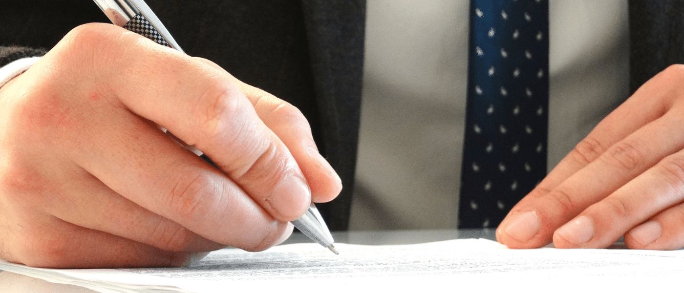 man in suit signing document